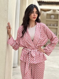 a woman wearing a red and white patterned pajama set