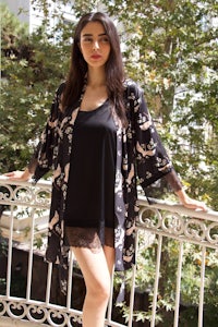 a woman in a black robe standing on a balcony