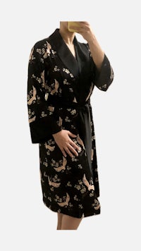 a woman is taking a selfie in a black robe